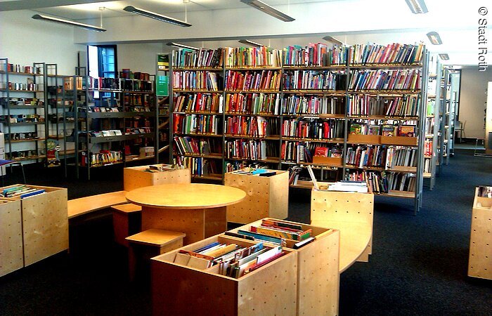 Innenaufnahme des umfangreichen Sortiments der barrierefreien Bücherei in Roth mit Sitzgelegenheiten