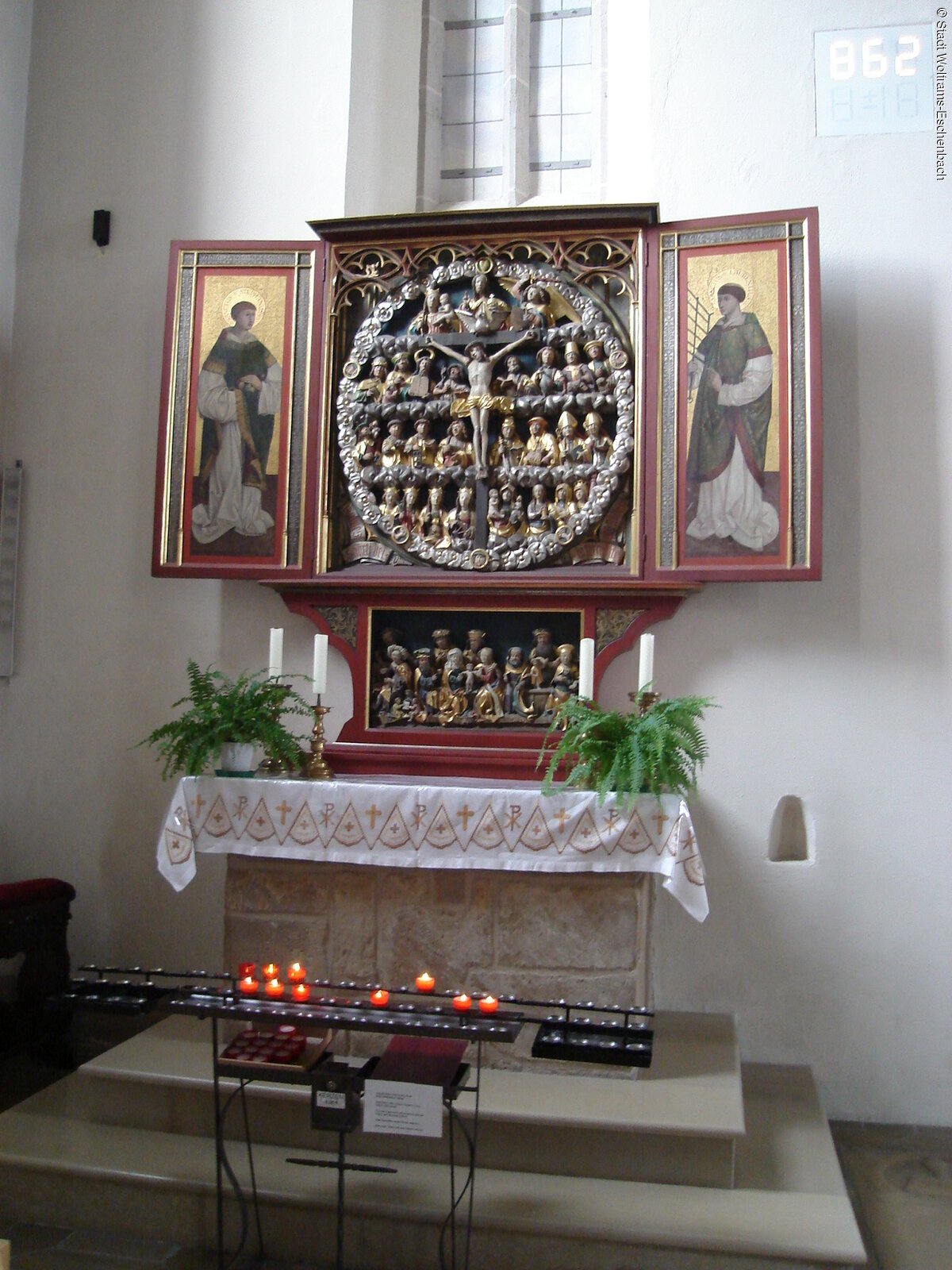 In der Kirche brennen einige Kerzen vor dem Altar.