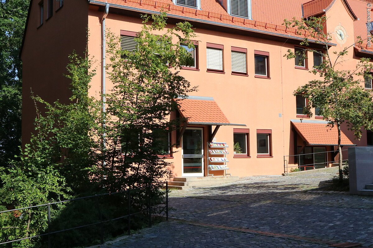 Amt für Kultur und Tourismus am Landratsamt Roth, Weinbergweg 1 in 91154 Roth. Ein großes Haus mit orangener Fassade. Das Haus hat drei Stöcke.