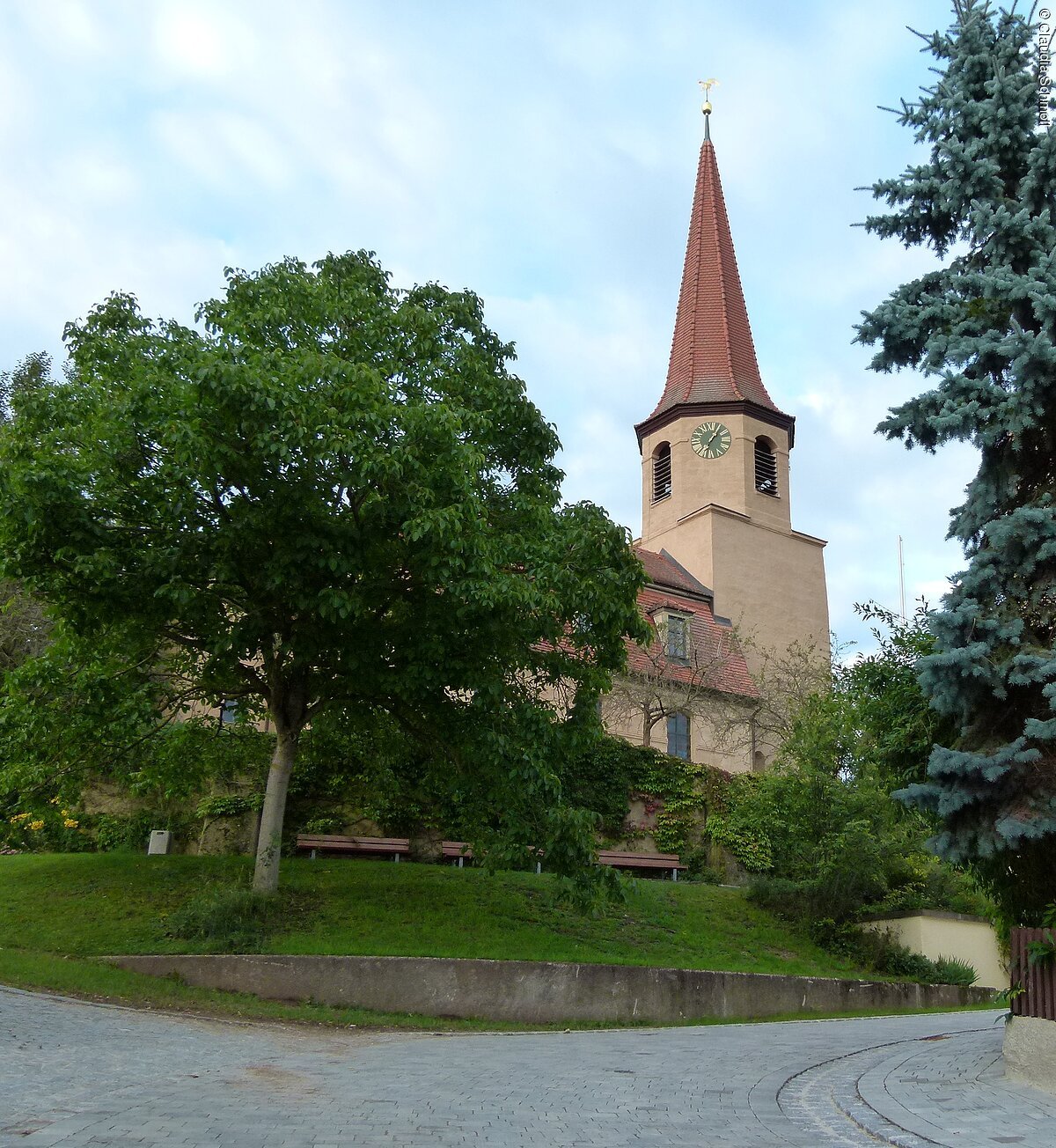 Die Pfofelder St. Michaelskirche aus Sandstein mit halbrunder Apsis samt Rundbogenfries und den kleinen Rundbogenfenstern am Langhaus.