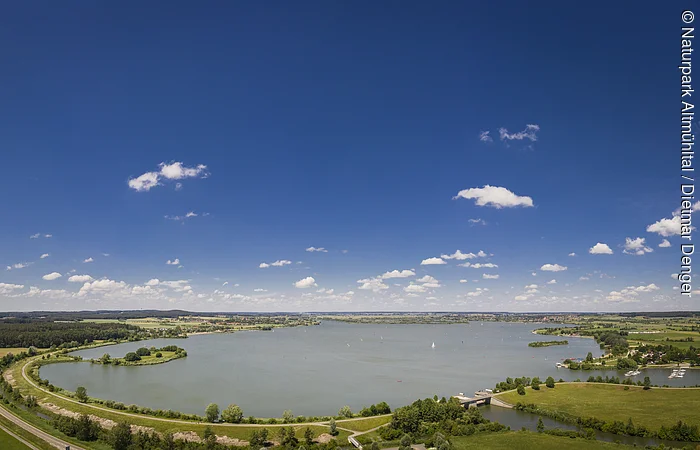 Der Altmühlsee bei Gunzenhausen bei hellblauem Himmel von oben komplett zu sehen.