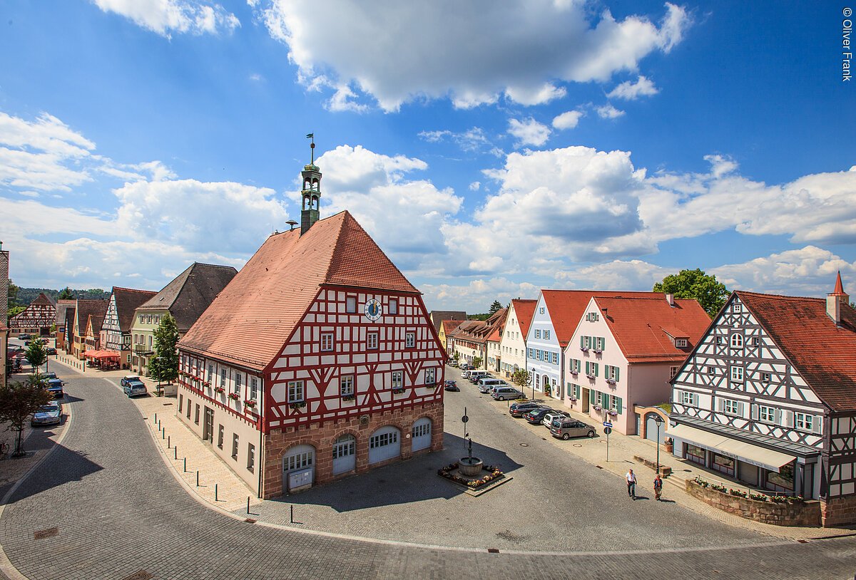 Luftbild einer Altsadt mit Fachwerkhäusern und gepflasterten Straßen.