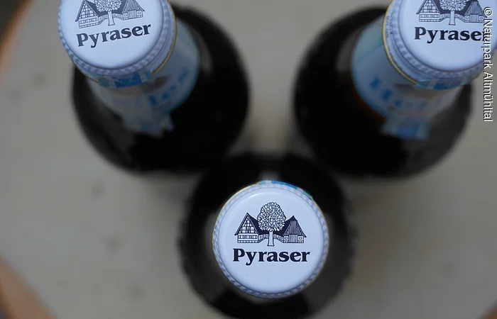 Draufsicht auf drei Flaschen mit dem Logo "Pyraser" auf den Kronkorken.
