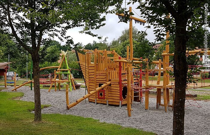 Freizeitpark "Am Bruckespan" Ein Spielplatz mit einem großem Spielgerät aus Holz. Das Klettergerüst ist in Form eines Schiffes.