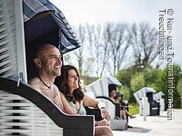 Nahaufnahme von einem Paar das lachend im Strandkorb sitzt. Nahaufnahme von einem Paar das lachend im Strandkorb sitzt.