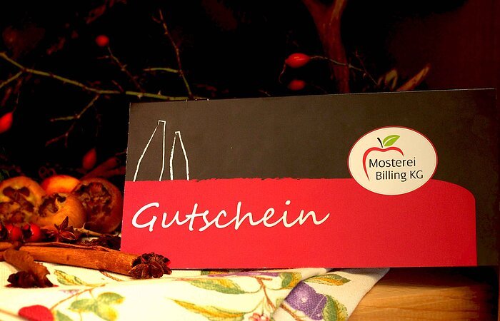 Gutschein der Mosterei Billing vor herbstlicher Dekoration