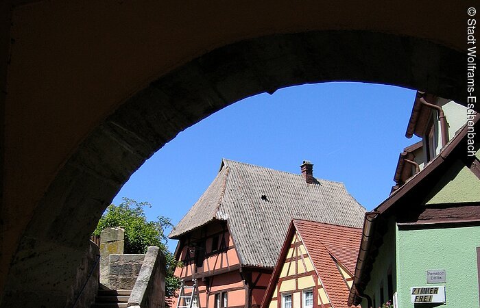 Auffällig ist seine Stellung, da der Westgiebel auf der Kirchhofmauer aufsitzt und die Färbergasse in einem Bogen überspannt.