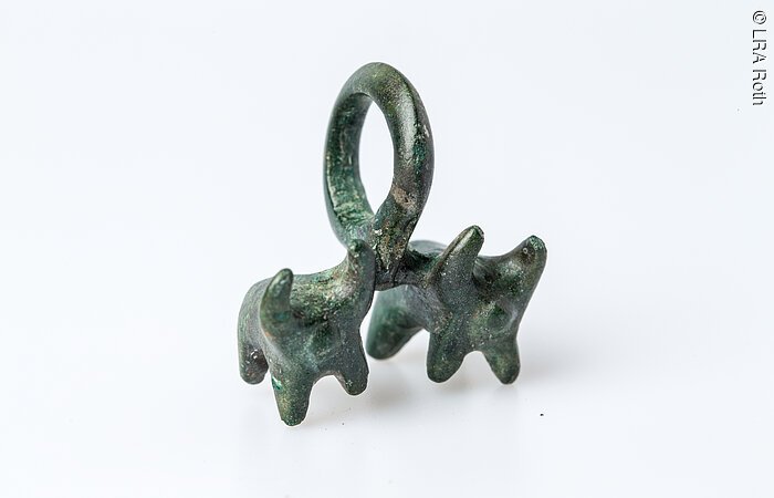 Ein Anhänger mit zwei Stierfiguren an einer Öse.