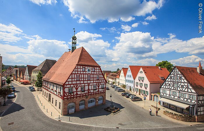 Luftbild einer Altsadt mit Fachwerkhäusern und gepflasterten Straßen.