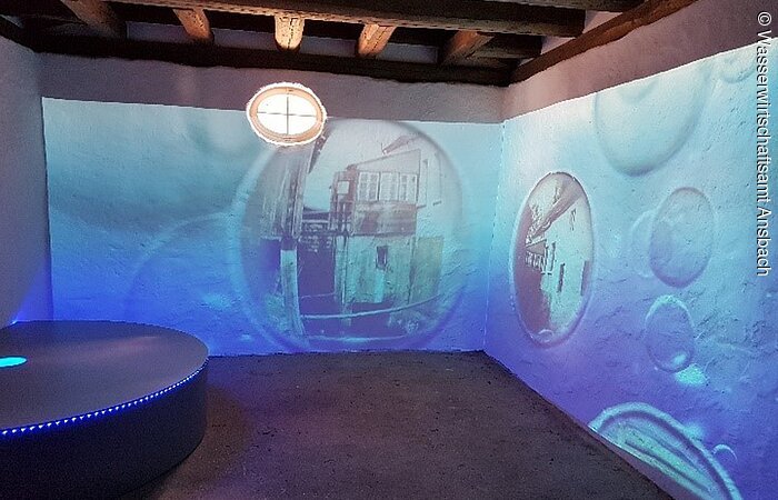Ehemaliges Backhaus. Blaue Projektionen an den Wänden.