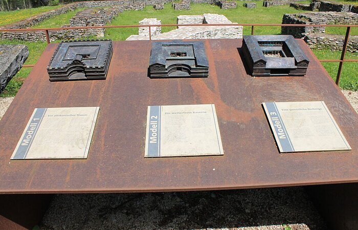 Römerbauten Auf einer Metallplatte sind drei verschiednee Modelle von römischen Bauwerken befestigt. Unter jedem Modell ist eine Informationstafel angebracht.