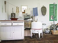 Blick in die Abteilung Leben im 20. Jahrhundert der Dauerausstellung; Zu sehen sind Exponate aus dem Bereicht „Wäsche waschen wie Früher“
