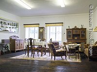 Aufnahme der Dauerausstellung des Museums Treuchtlingen mit Blick in die Abteilung Leben im 20. Jahrhunderts; Zu sehen sind eine Wohn- / Esszimmereinrichtung aus dem frühen 20. Jahrhundert.