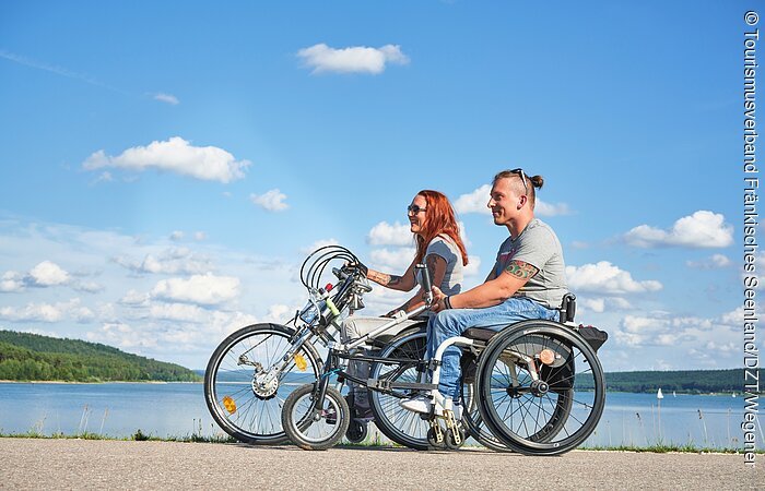 Handbiketour am Großen Brombachsee Zwei Handbiker stehen auf dem Damm zwischen dem Kleinen und dem Großen Brombachsee und genießen den Ausblick über die zwei Seen.