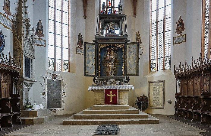 Rieter-Kirche Kalbensteinberg Innenraum einer Kirche. Weiße Fassade mit hohen Fenstern. Blick auf den Altar mit Treppe und Jungrau Maria mit Kleinkind auf dem Arm. Links und rechts vom Altar Bänke aus dunklem Holz.
