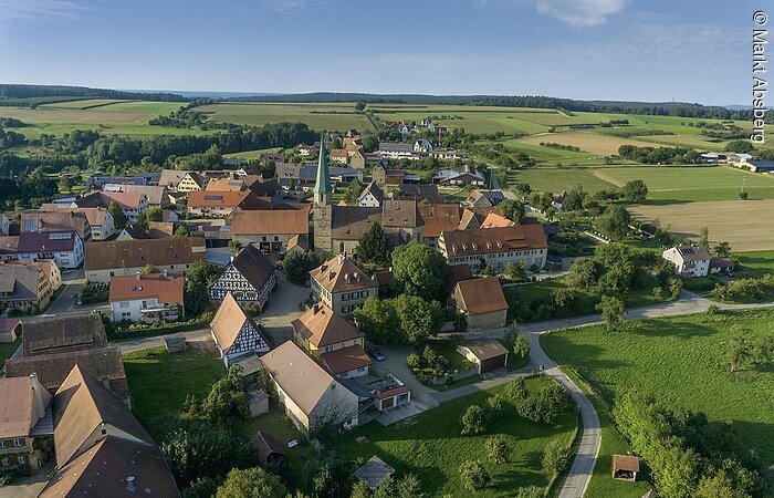 Kalbensteinberg Luftbild von Kalbensteinberg. Blick auf die Rieter-Kirche umgeben von Wohnhäusern. Um den Ortsteil erstrecken sich grüne Felder.