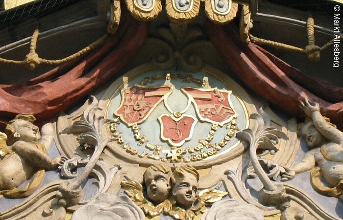 Wappen mit verschiedenen Farben: blau, gelb, rot, Gold.