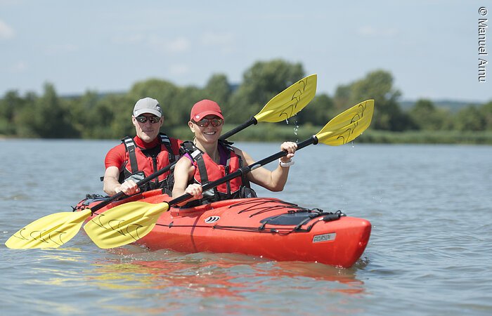 Kajakfahrer Vater und Tochter im Kajak am See und halten ihr Paddel in den Händen.