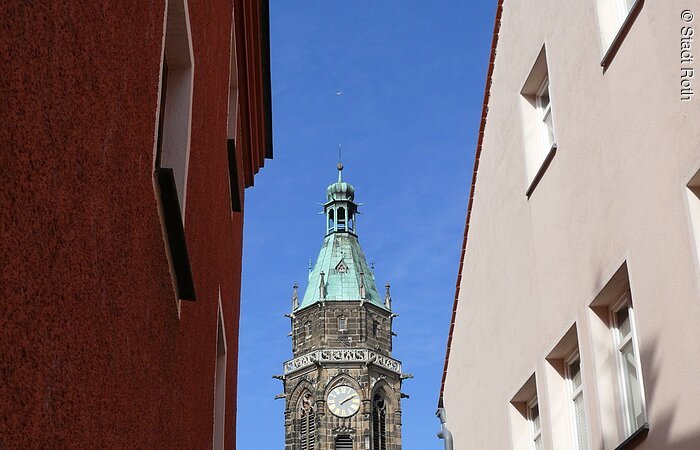 Sicht auf den Kirchturm der Evangelischen Stadtpfarrkirche in Roth. Der Turm enthält romantische Elemente.