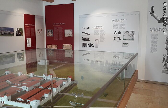 Innenraum eines Museums. In der Raummitte ein Modell eines römischen Kastellls. An der weißen Wand Infotafeln.