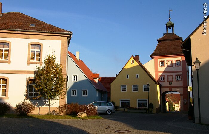 Die Sonne wirft Schatten auf das Arberger Torturm, wessen Spitze aber bestrahlt ist.