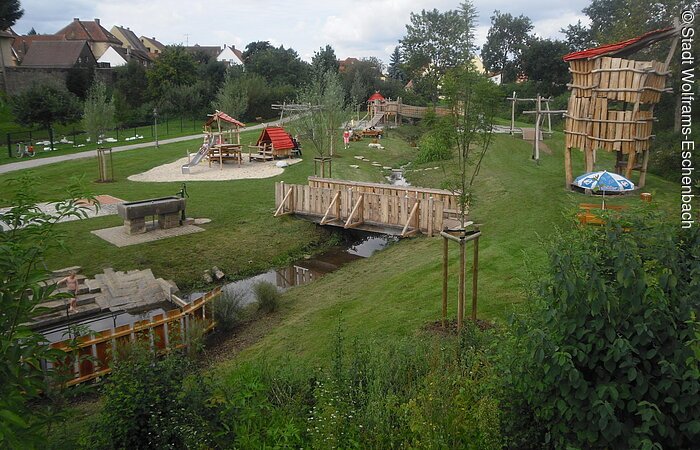Viel zu erkunden auf dem Ritterspielplatz in Wolframs-Eschenbach Der große Ritterspielplatz auf einer grünen Wiese in Wolframs-Eschenabch mit Klettergerüst, Schauckel, Rutsche und Kneippanalage.